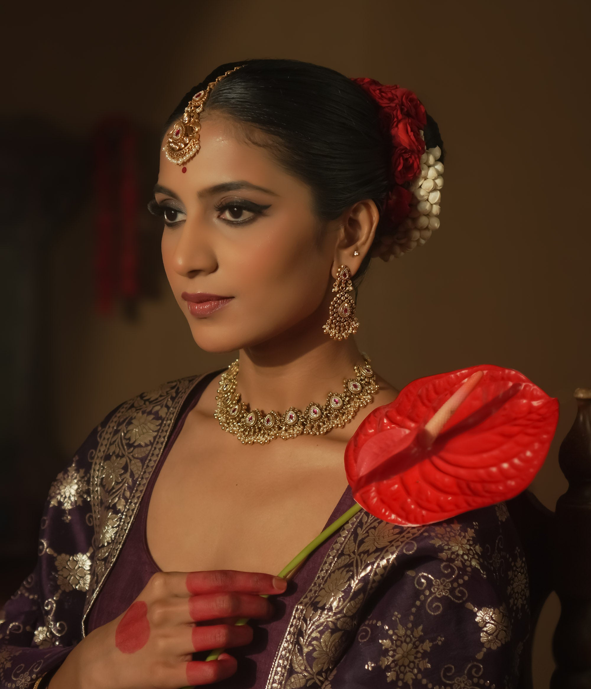 Gold-plated silver earrings with a teardrop shape, red gems, and cascading gold and pearl balls.