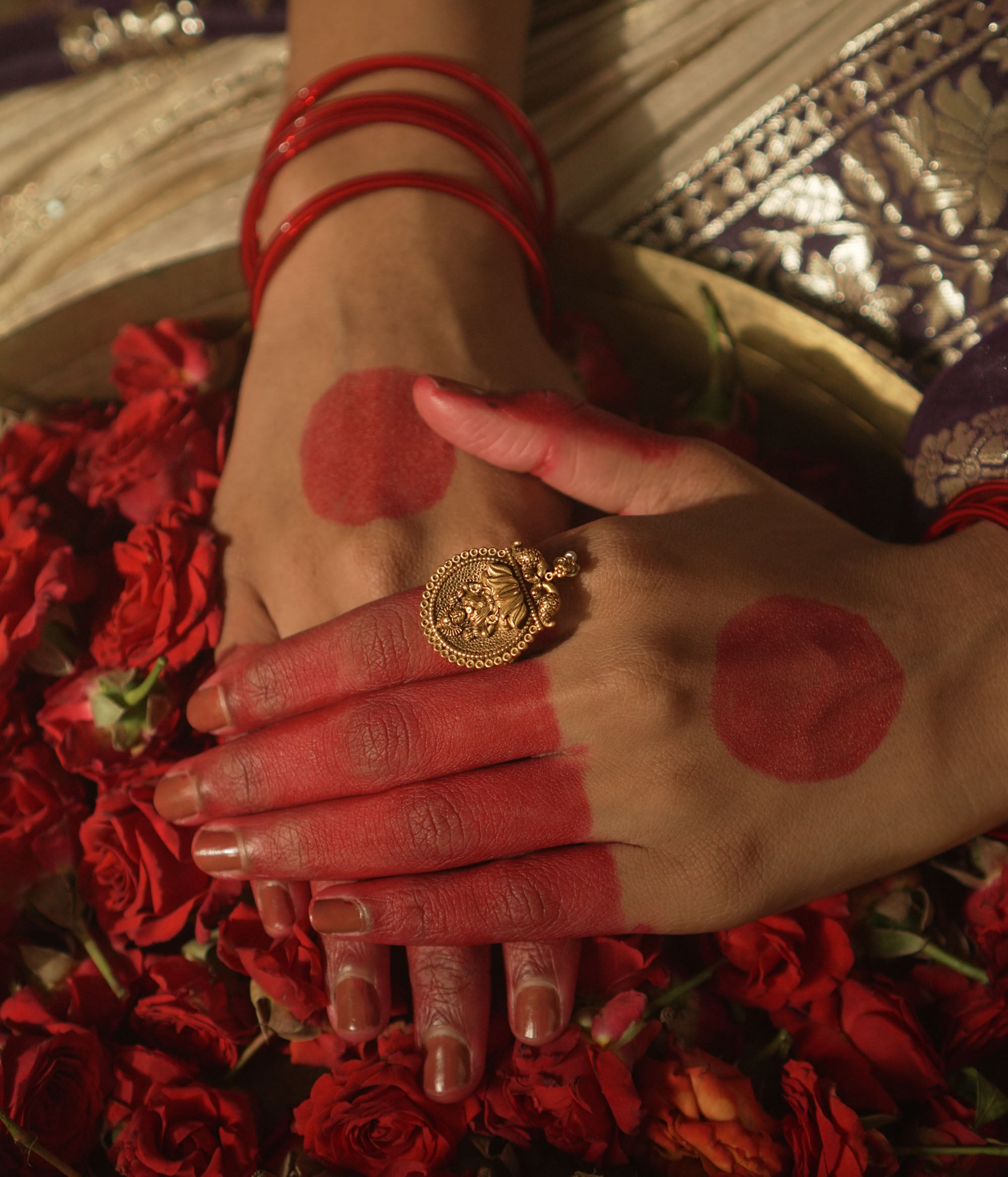 Gold ring with a central Lakshmi goddess motif and beaded edges.