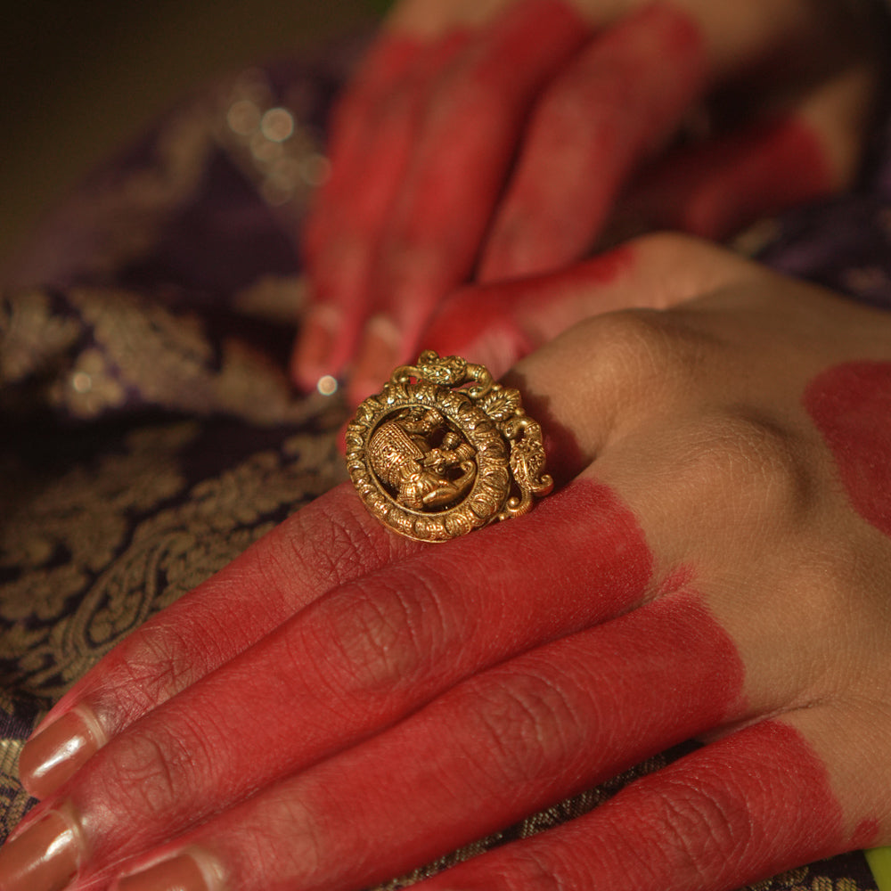 Gold ring with a central gaja (elephant) motif and swirling patterns.