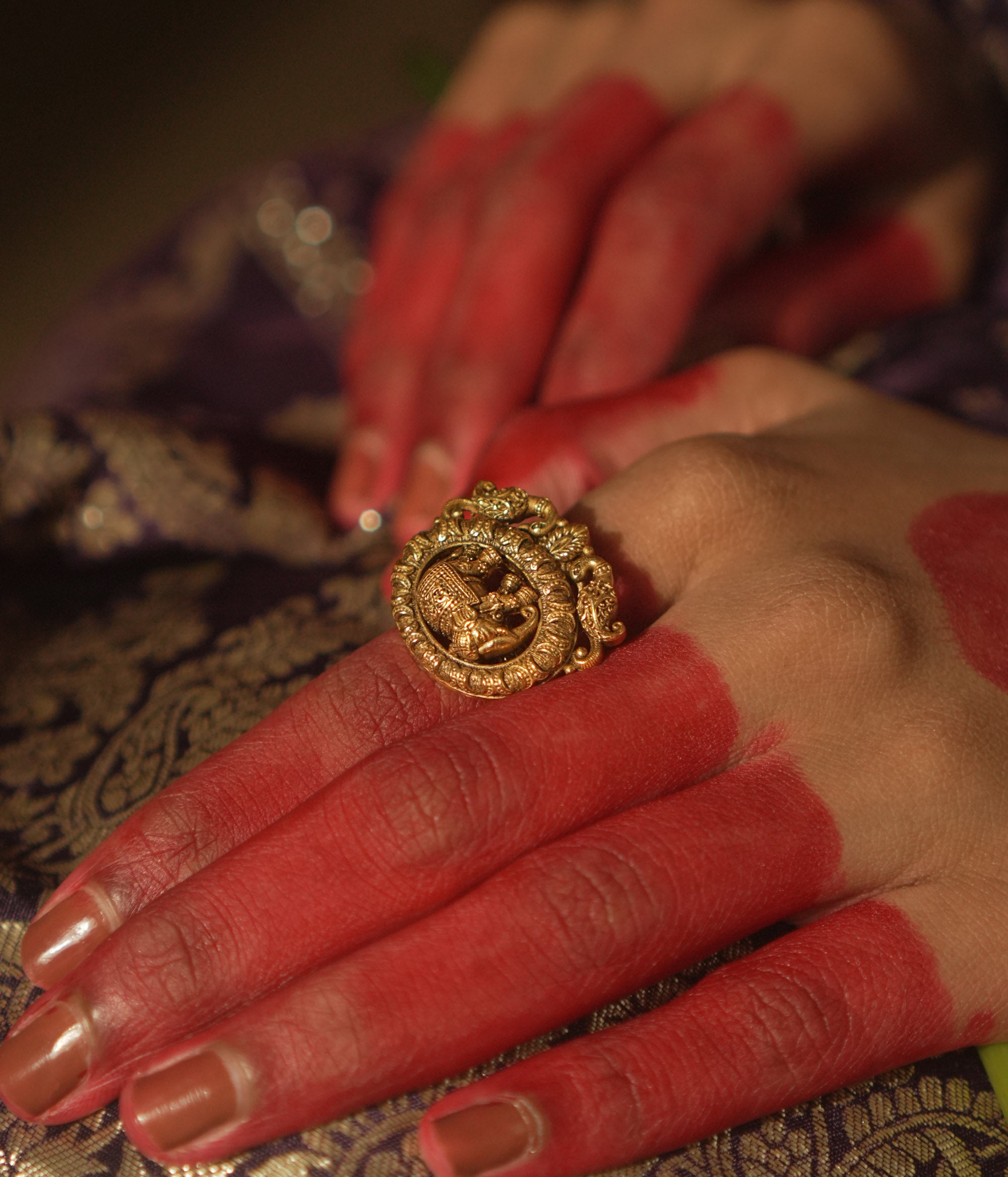 Gold ring with a central gaja (elephant) motif and swirling patterns.