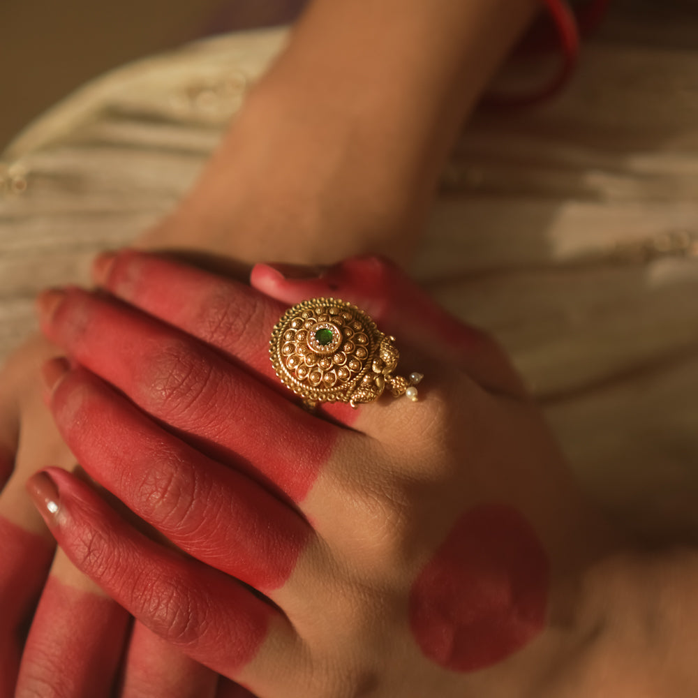 Gold-plated silver ring with filigree and a tiny green gemstone.