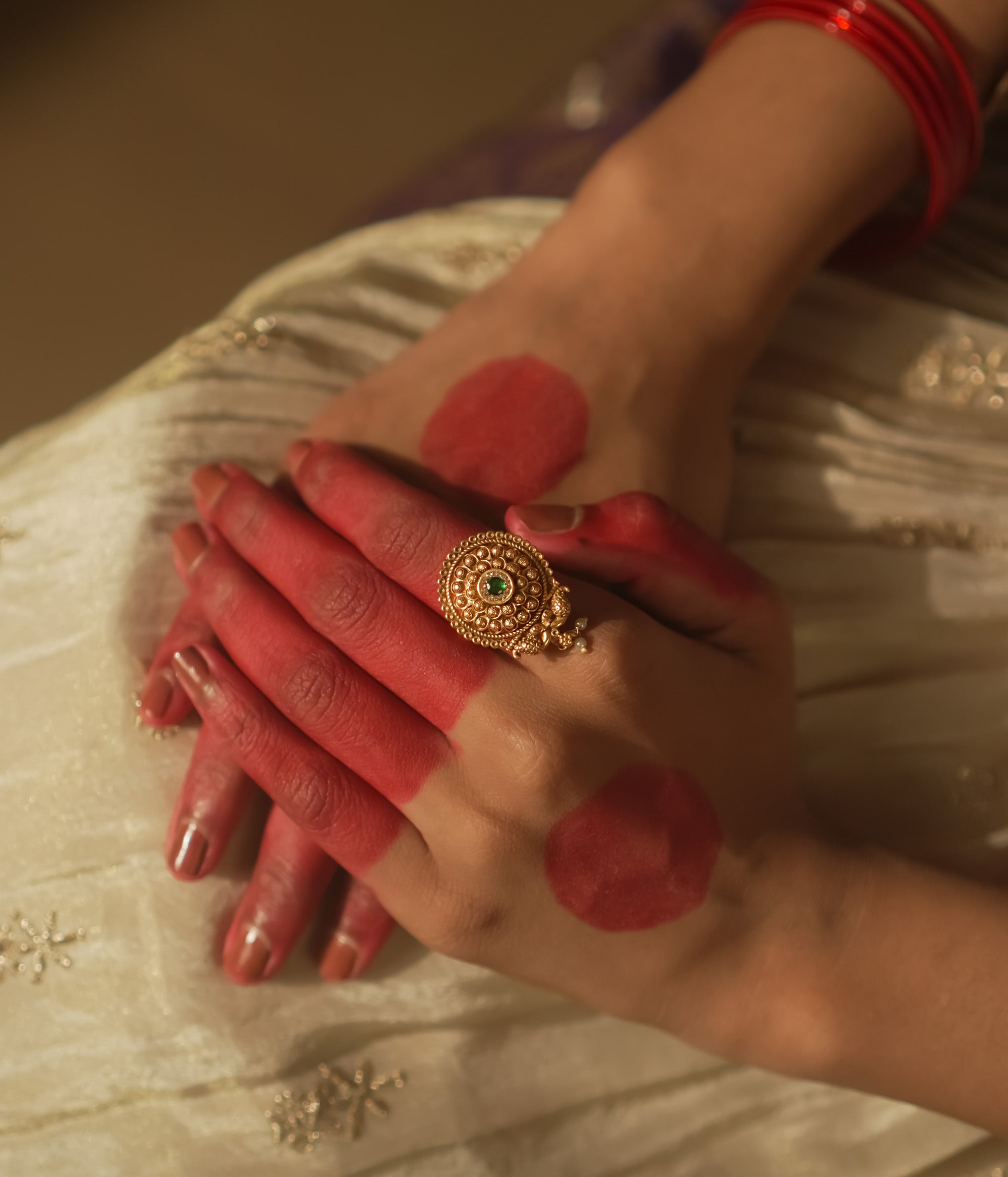 Gold-plated silver ring with filigree and a tiny green gemstone.