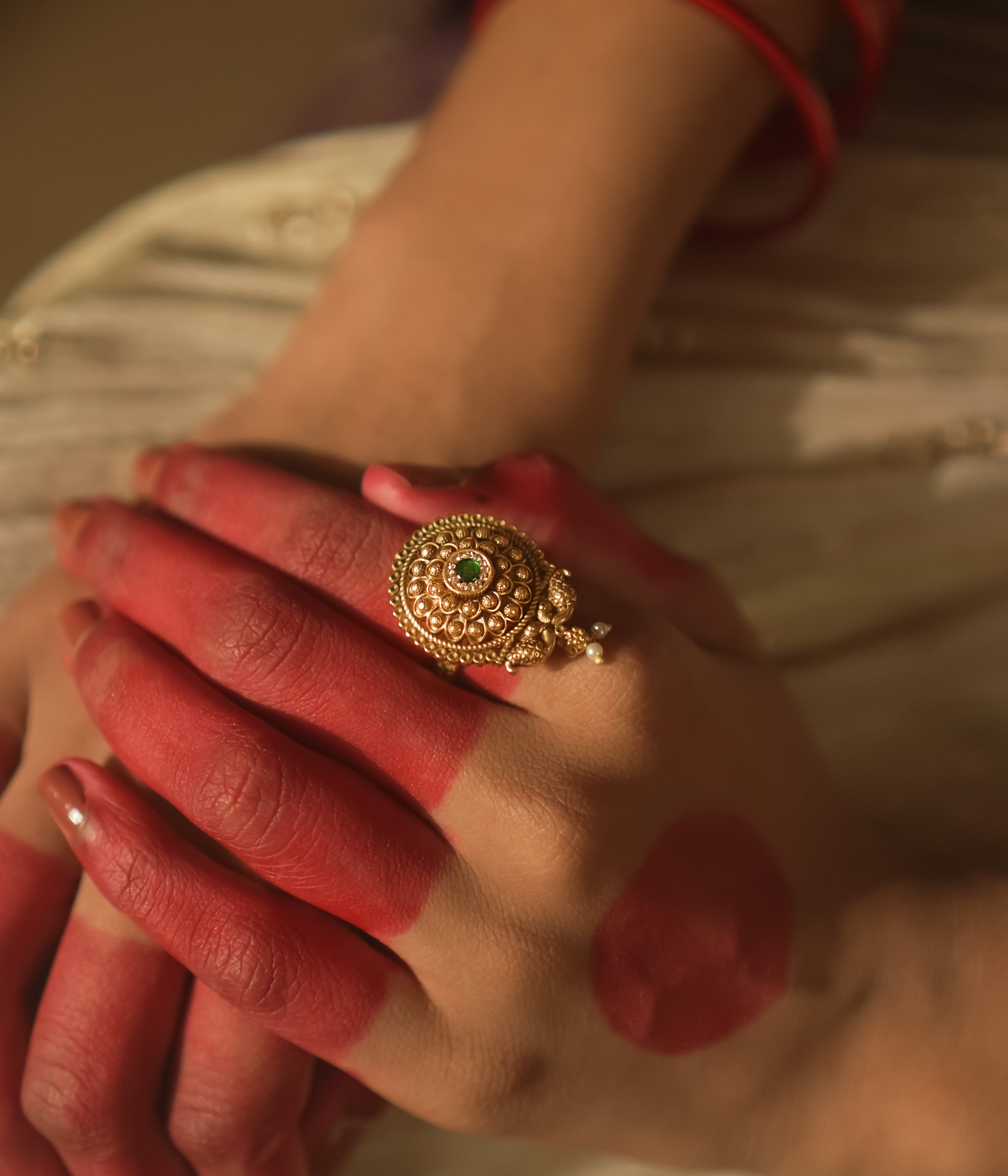Gold-plated silver ring with filigree and a tiny green gemstone.