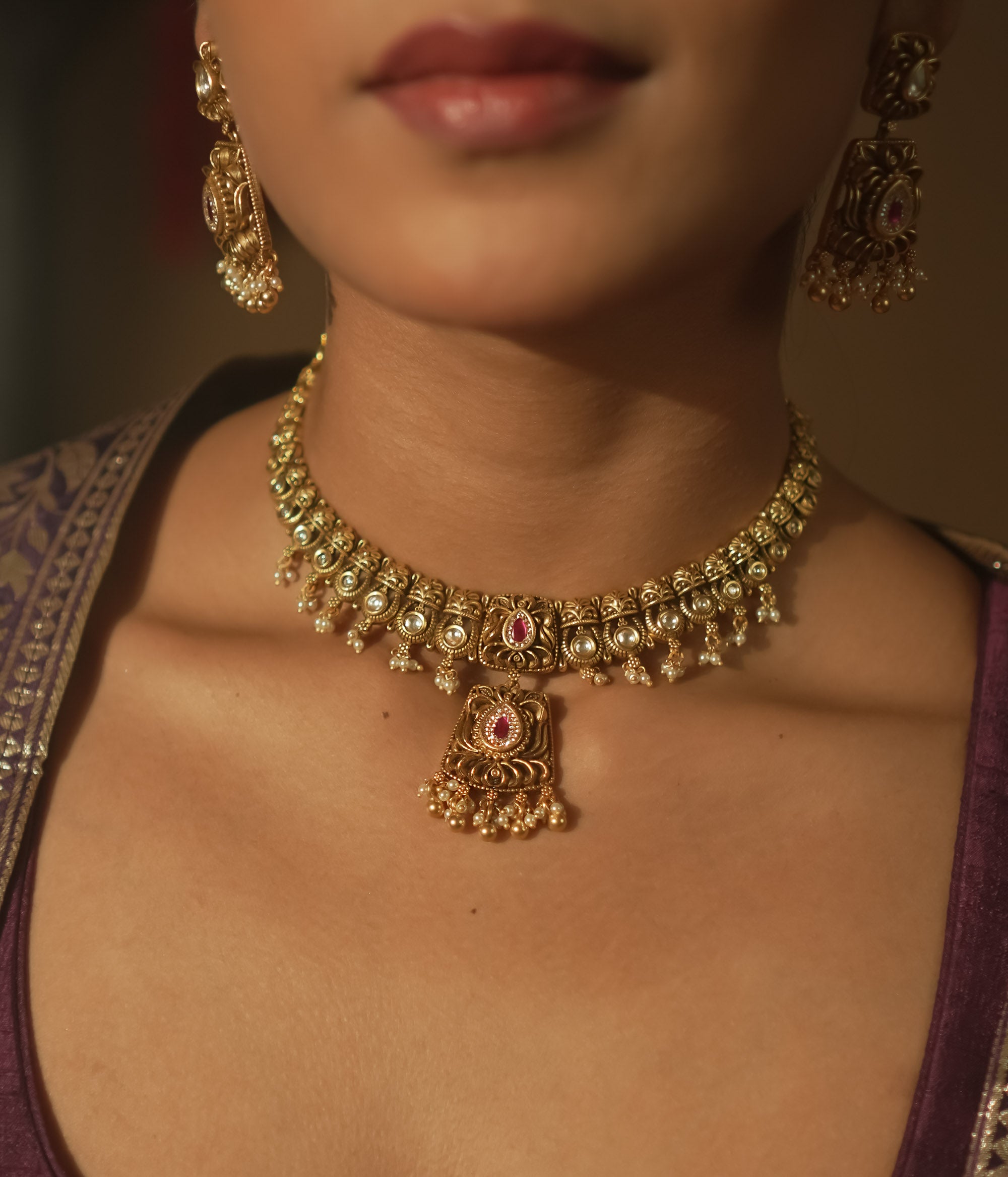 Gold mesh necklace with a central pendant with pearls and crimson gems.