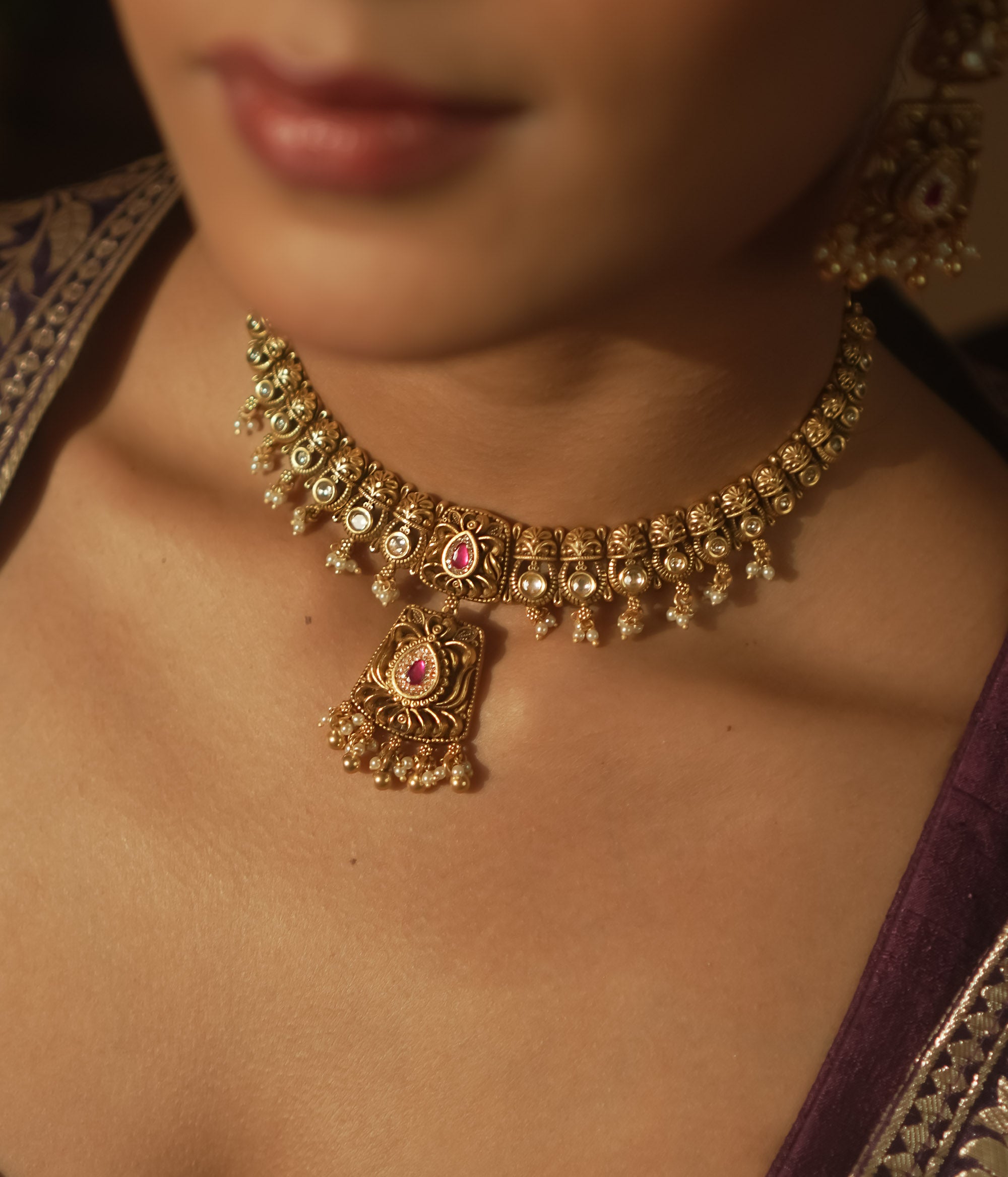 Gold mesh necklace with a central pendant with pearls and crimson gems.
