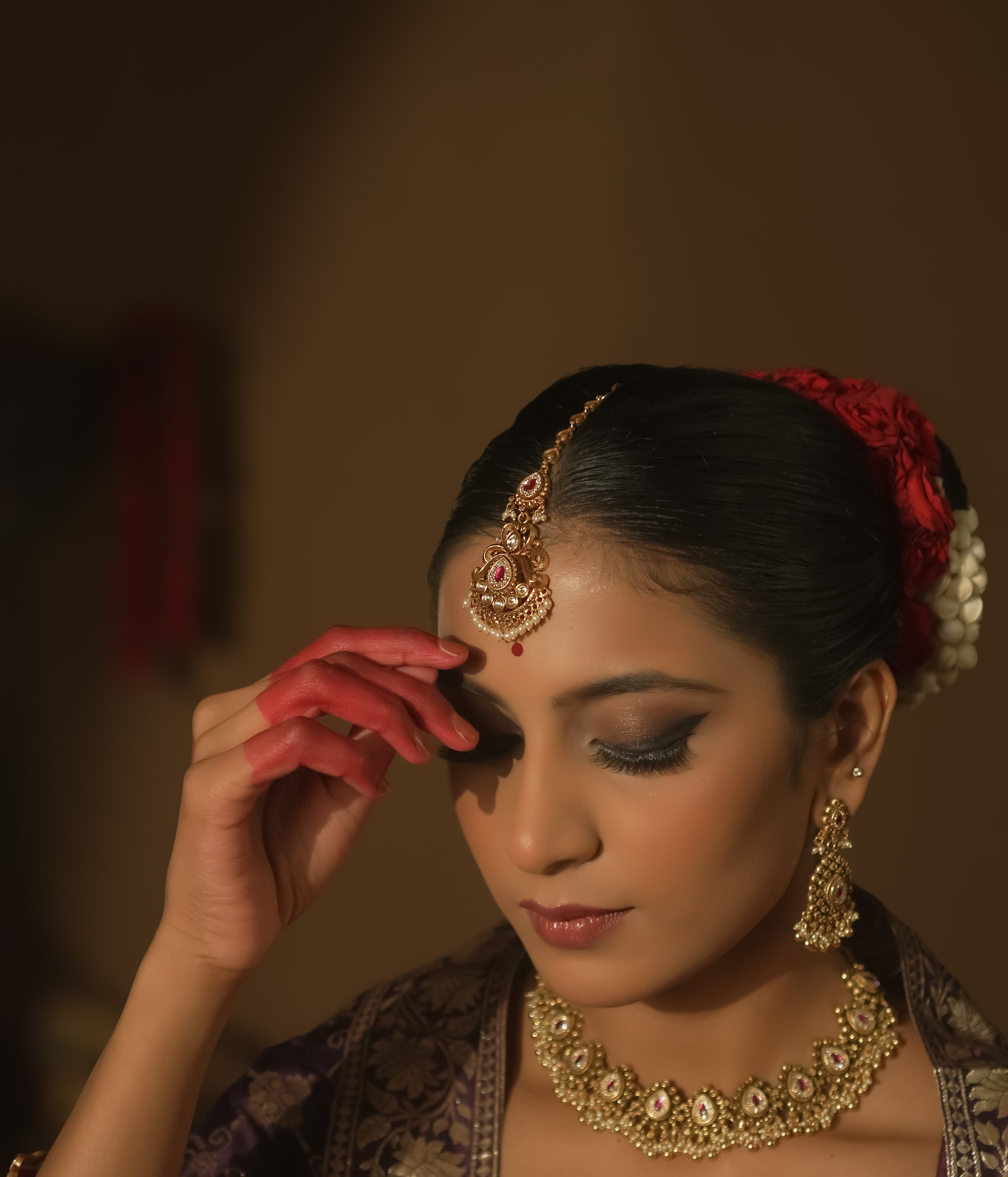 Maangtika with gold swirls, cultured rubies, pearls, and a dangling red gemstone.