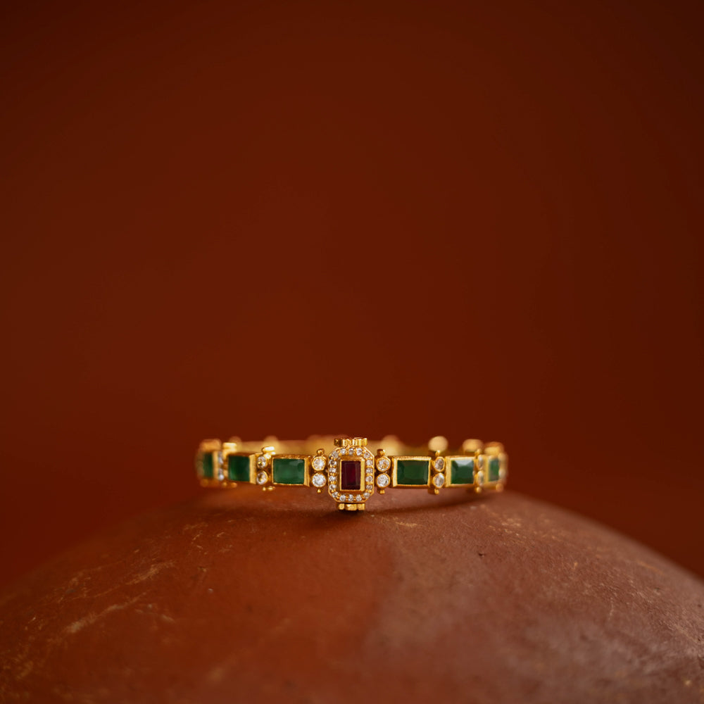 Gold bangle with red and green cut stones and CZ detailing from the Stone Collection.
