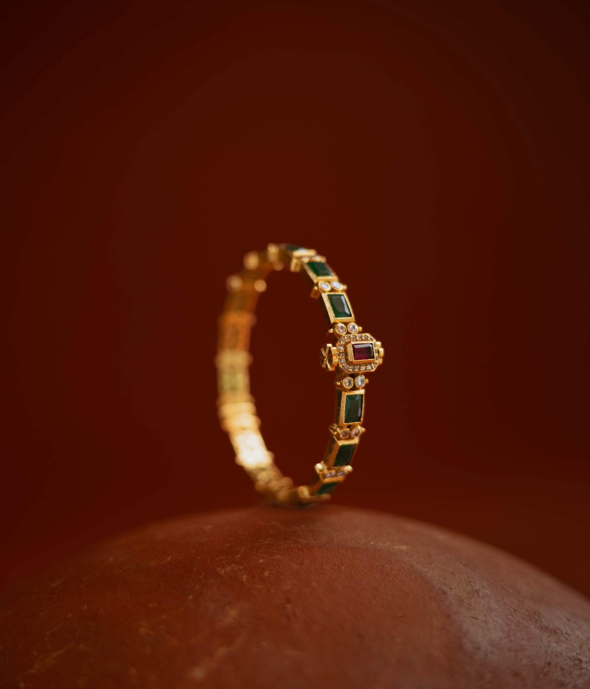 Gold bangle with red and green cut stones and CZ detailing from the Stone Collection.