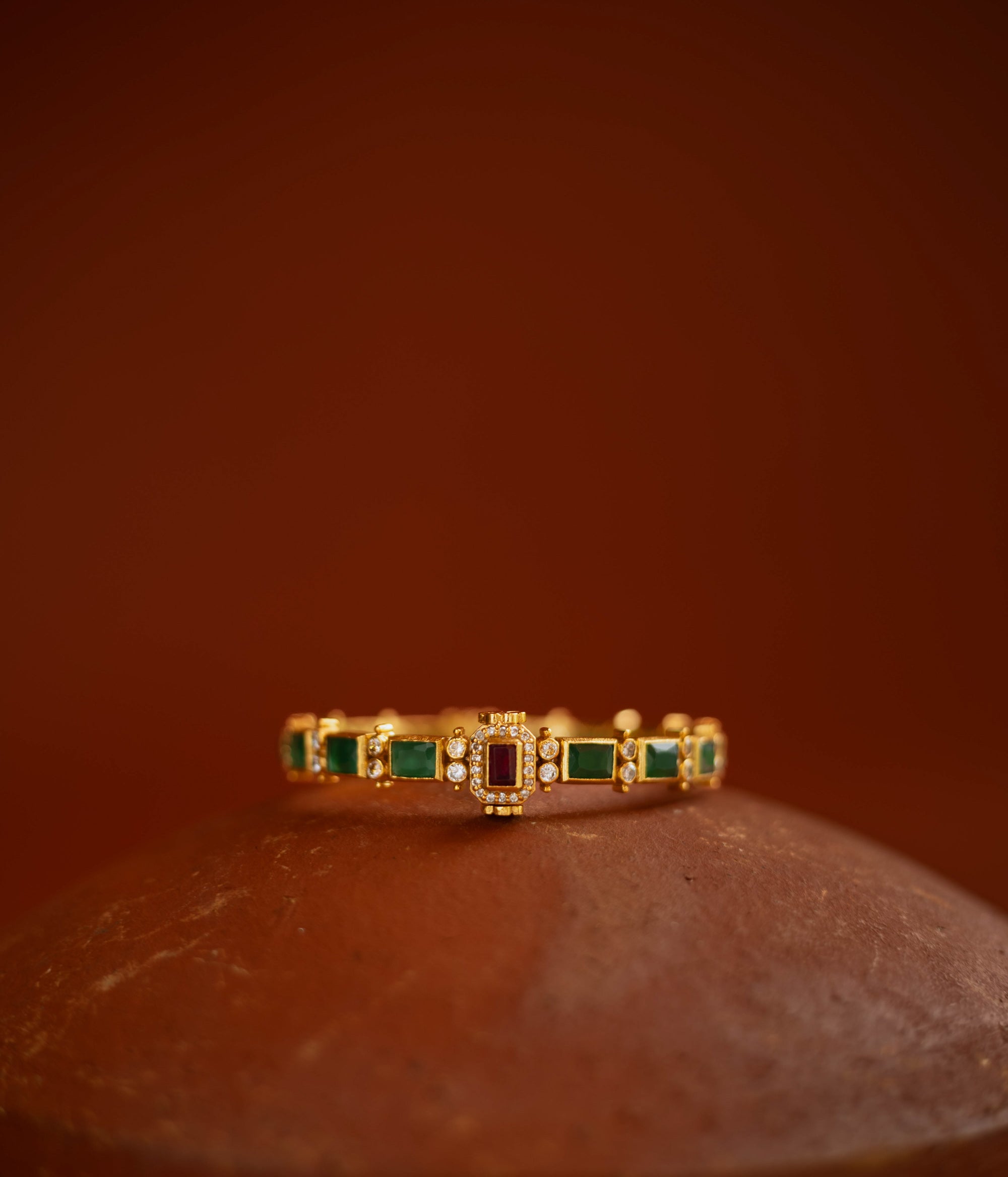 Gold bangle with red and green cut stones and CZ detailing from the Stone Collection.
