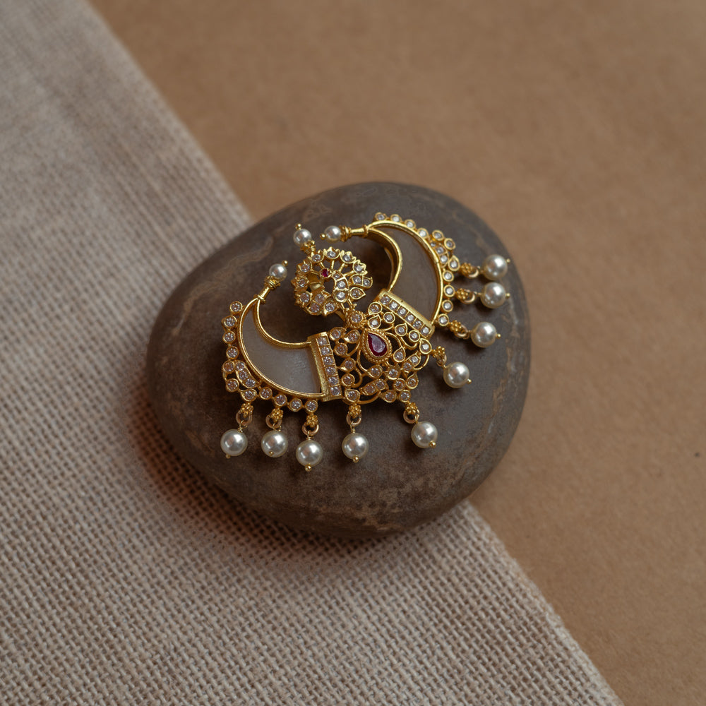 Gold pendant in twin crescent shape with CZ stones, pearls, and red spinal stone.
