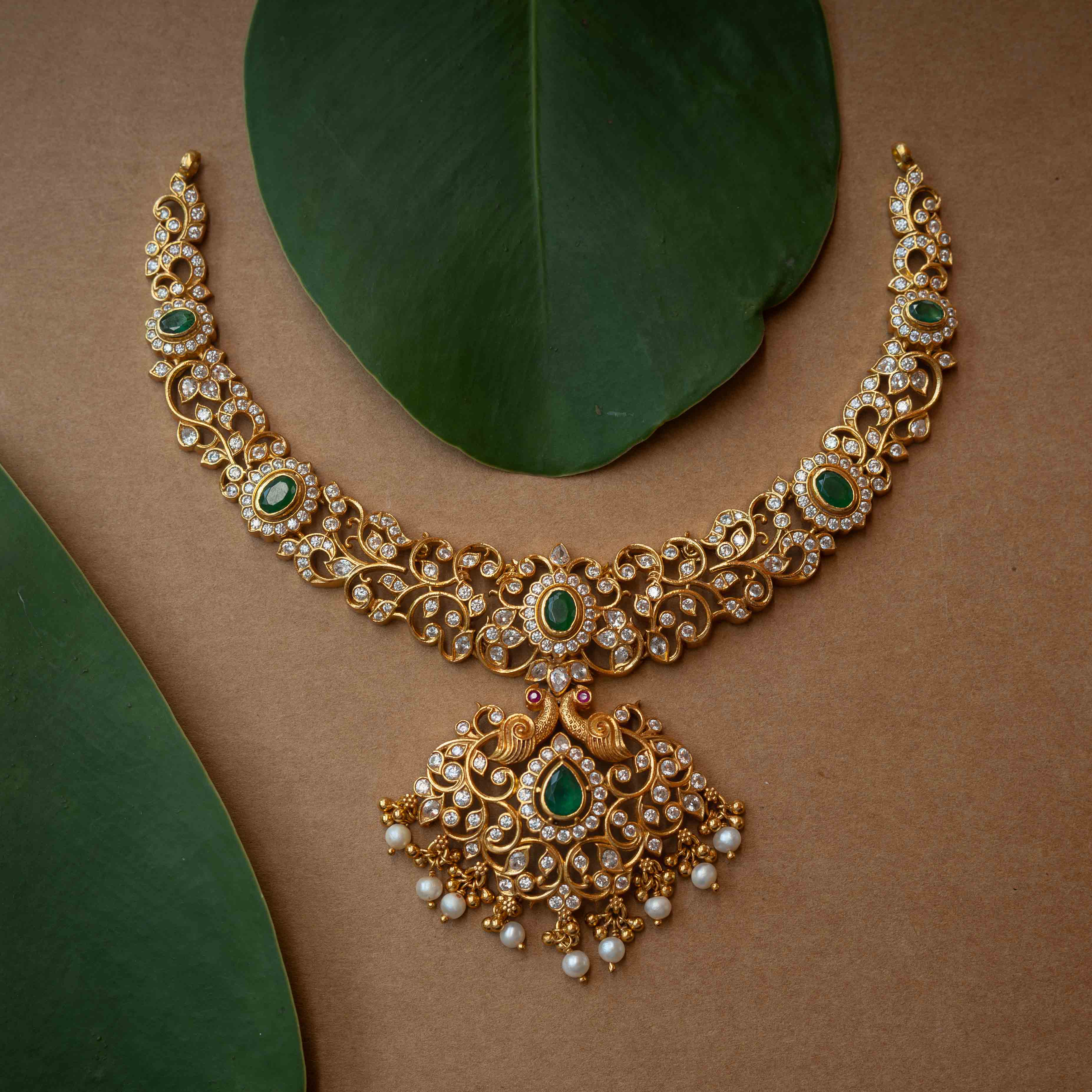 A multi-strand necklace with green, clear, and white stones and pearls.