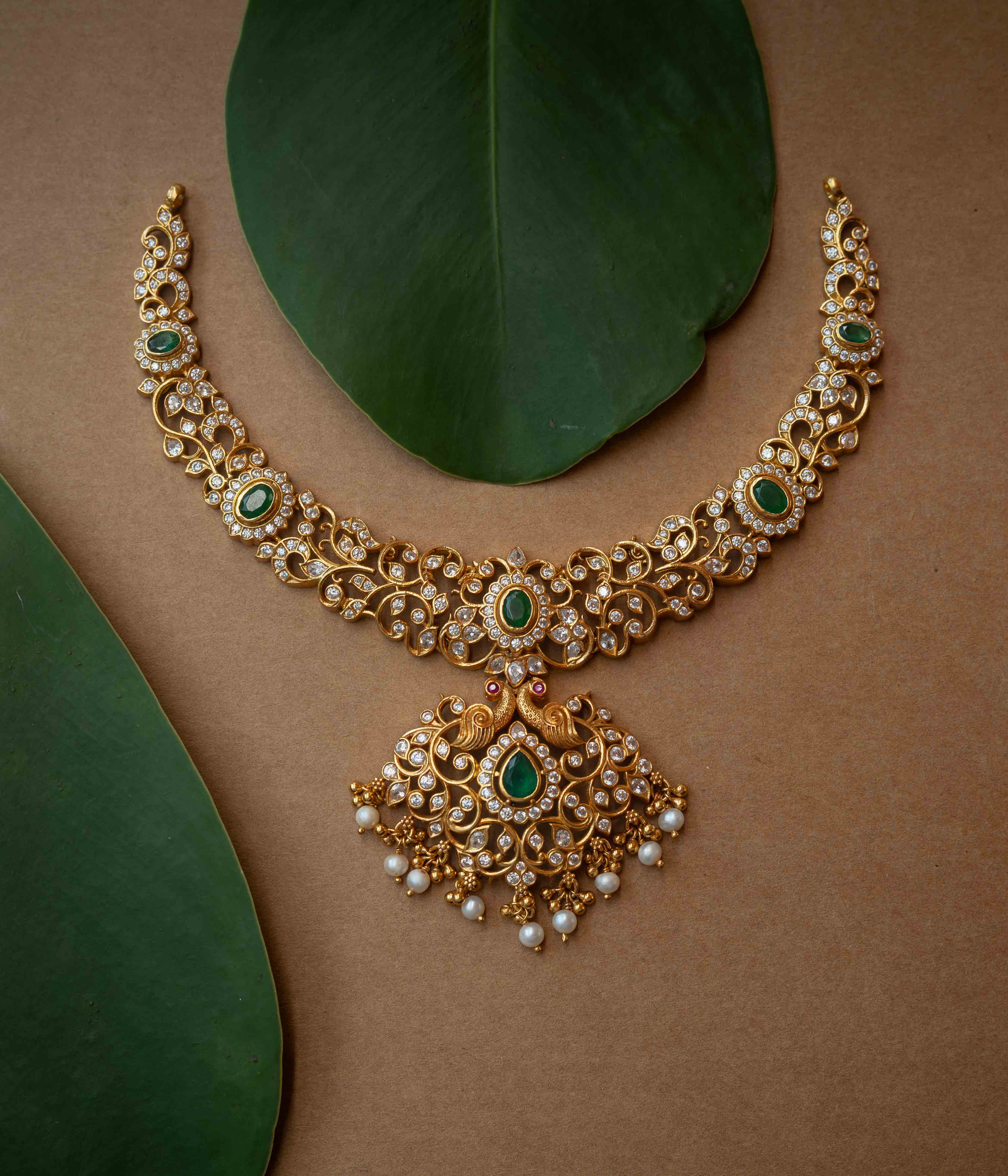 A multi-strand necklace with green, clear, and white stones and pearls.