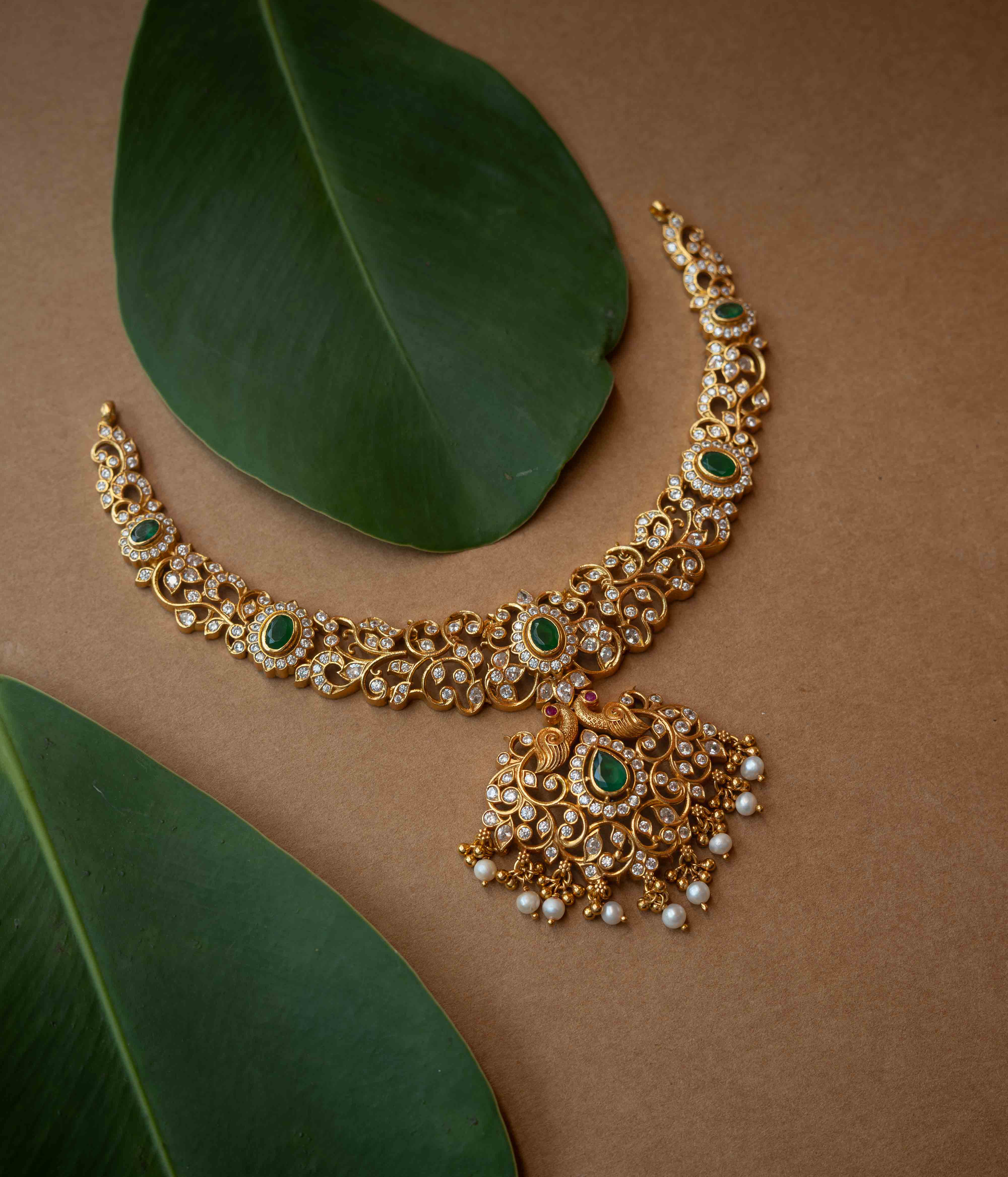 A multi-strand necklace with green, clear, and white stones and pearls.