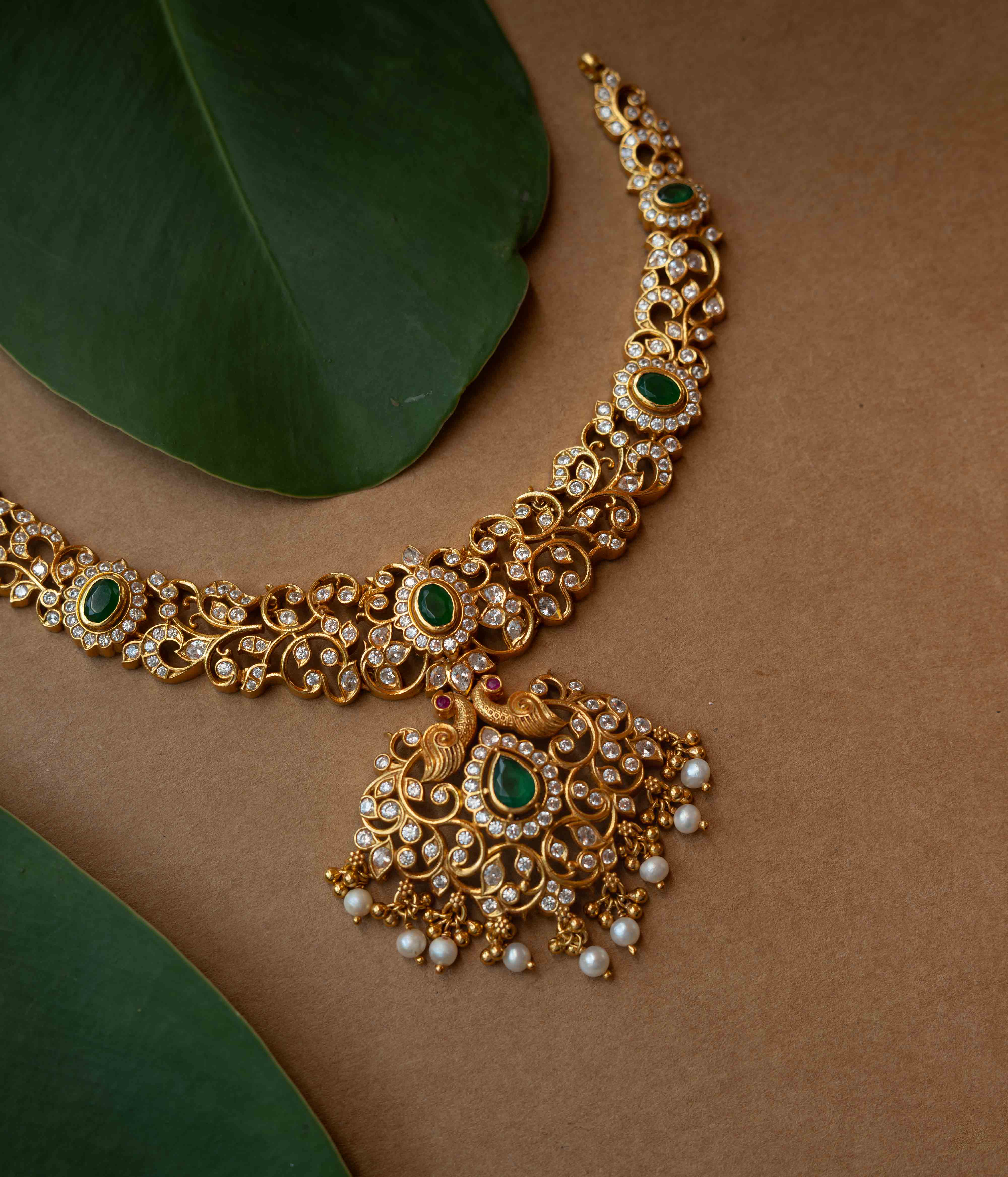 A multi-strand necklace with green, clear, and white stones and pearls.