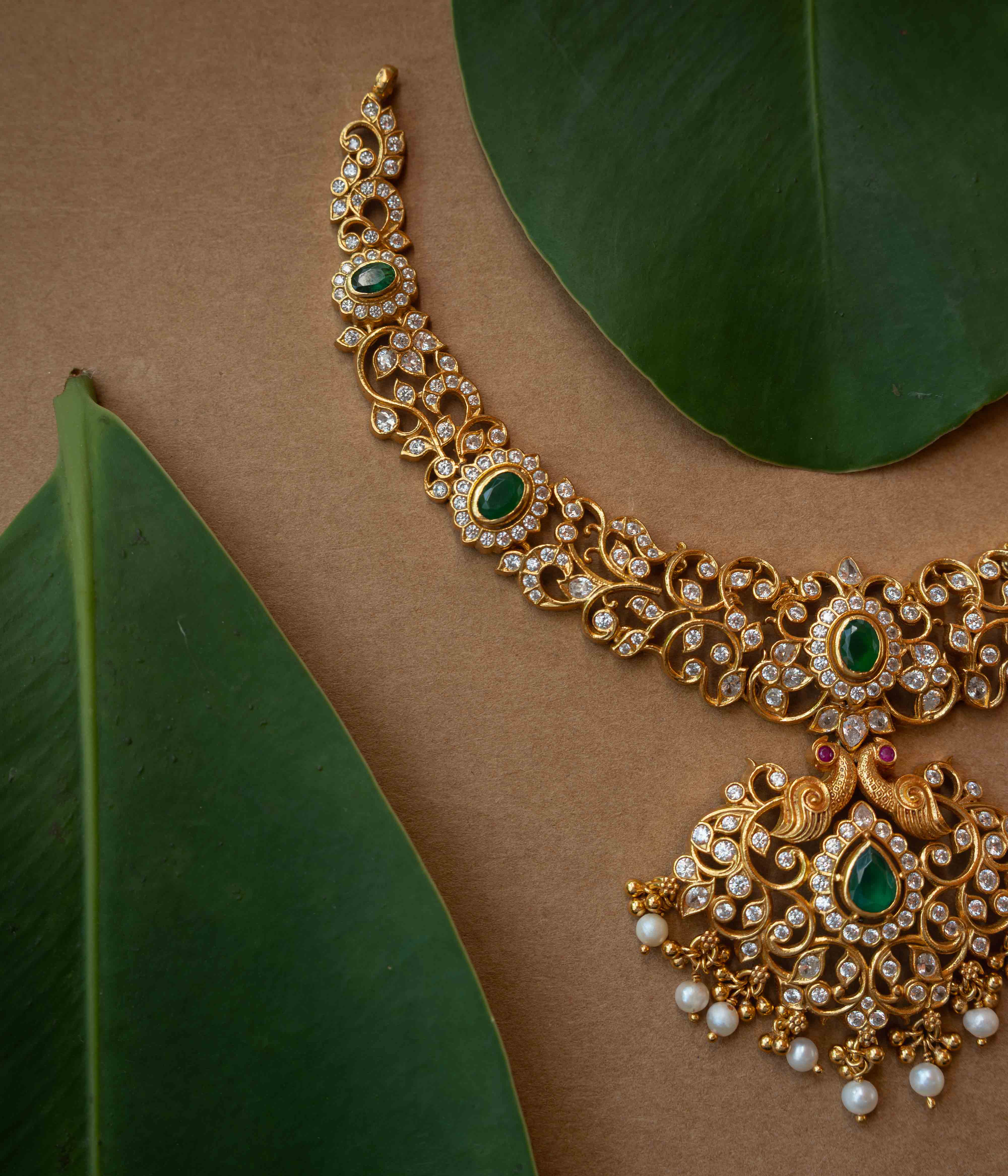 A multi-strand necklace with green, clear, and white stones and pearls.