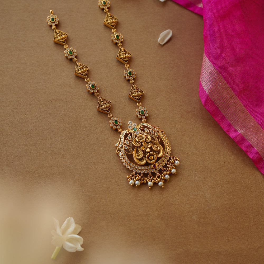 Temple-inspired gold necklace with peacock motif and Swarovski, red, and green spinal stones.
