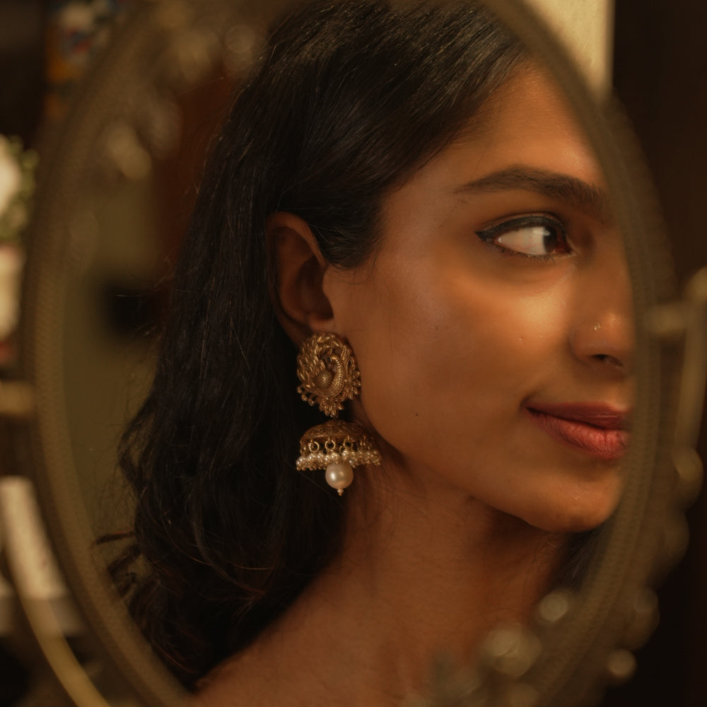 Tribal-style jhumka earrings with spiral top design, red spinel accents, and hanging pearl drop.