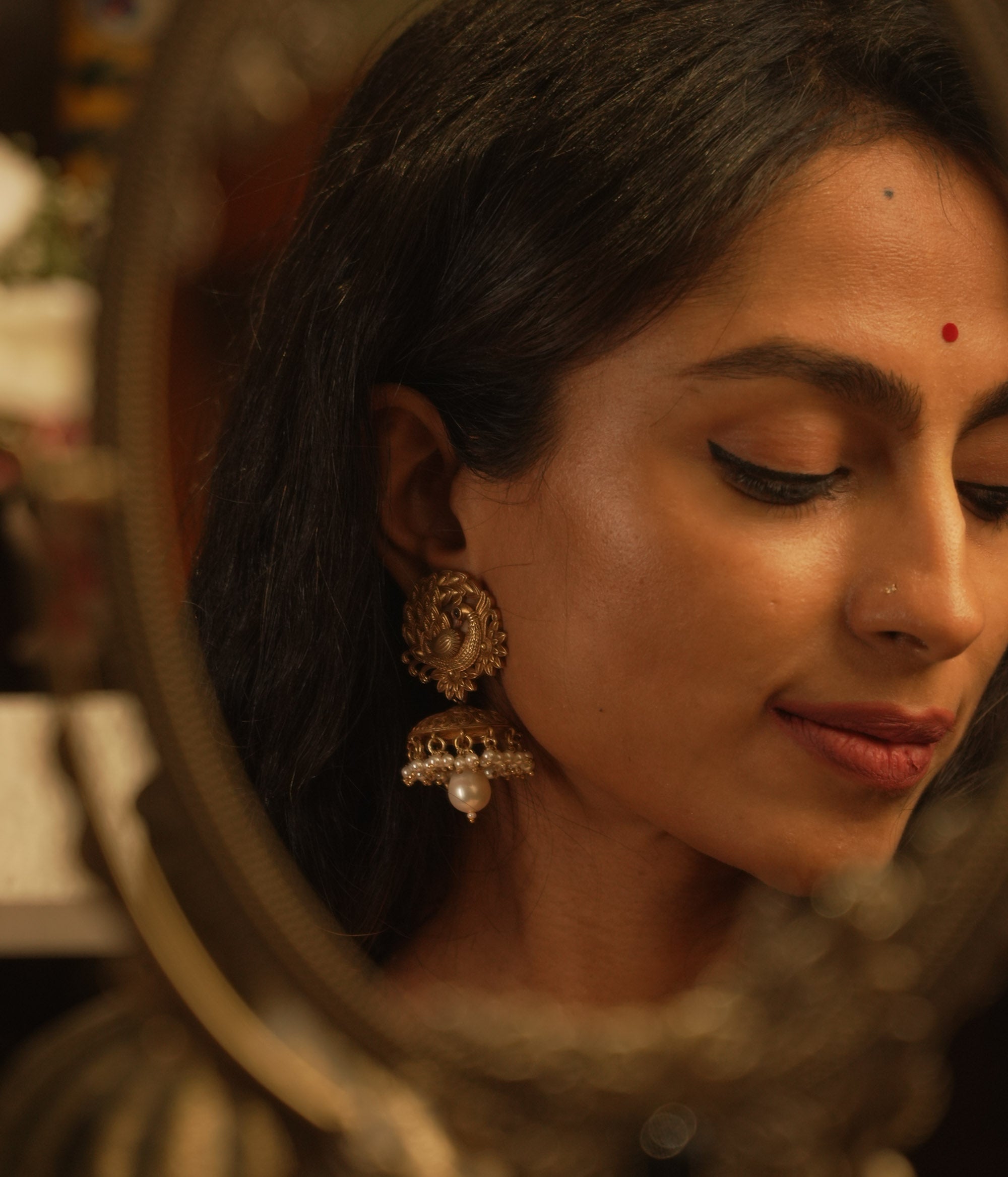 Tribal-style jhumka earrings with spiral top design, red spinel accents, and hanging pearl drop.