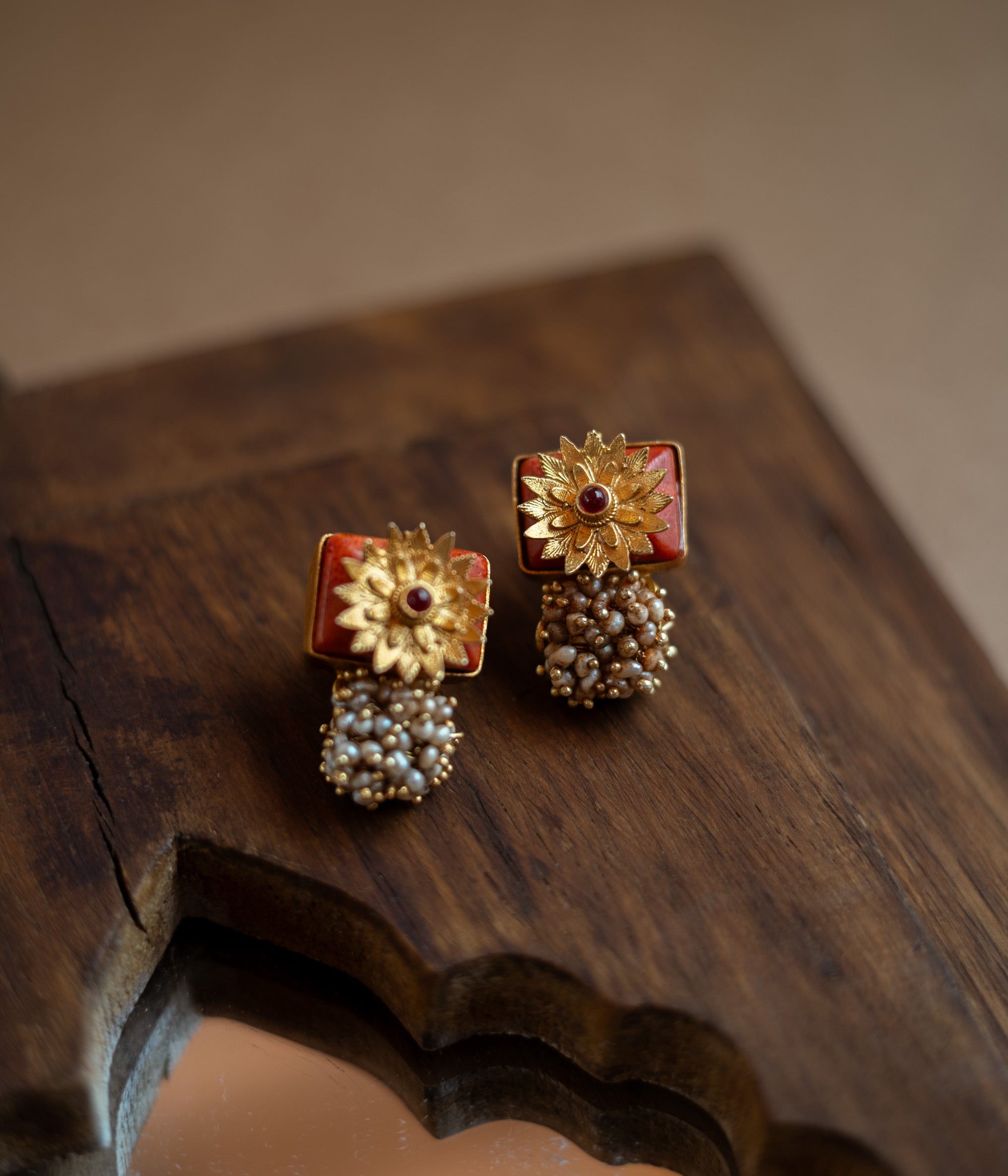 Bell-shaped earrings with a red spinel stone and pearl droplets.