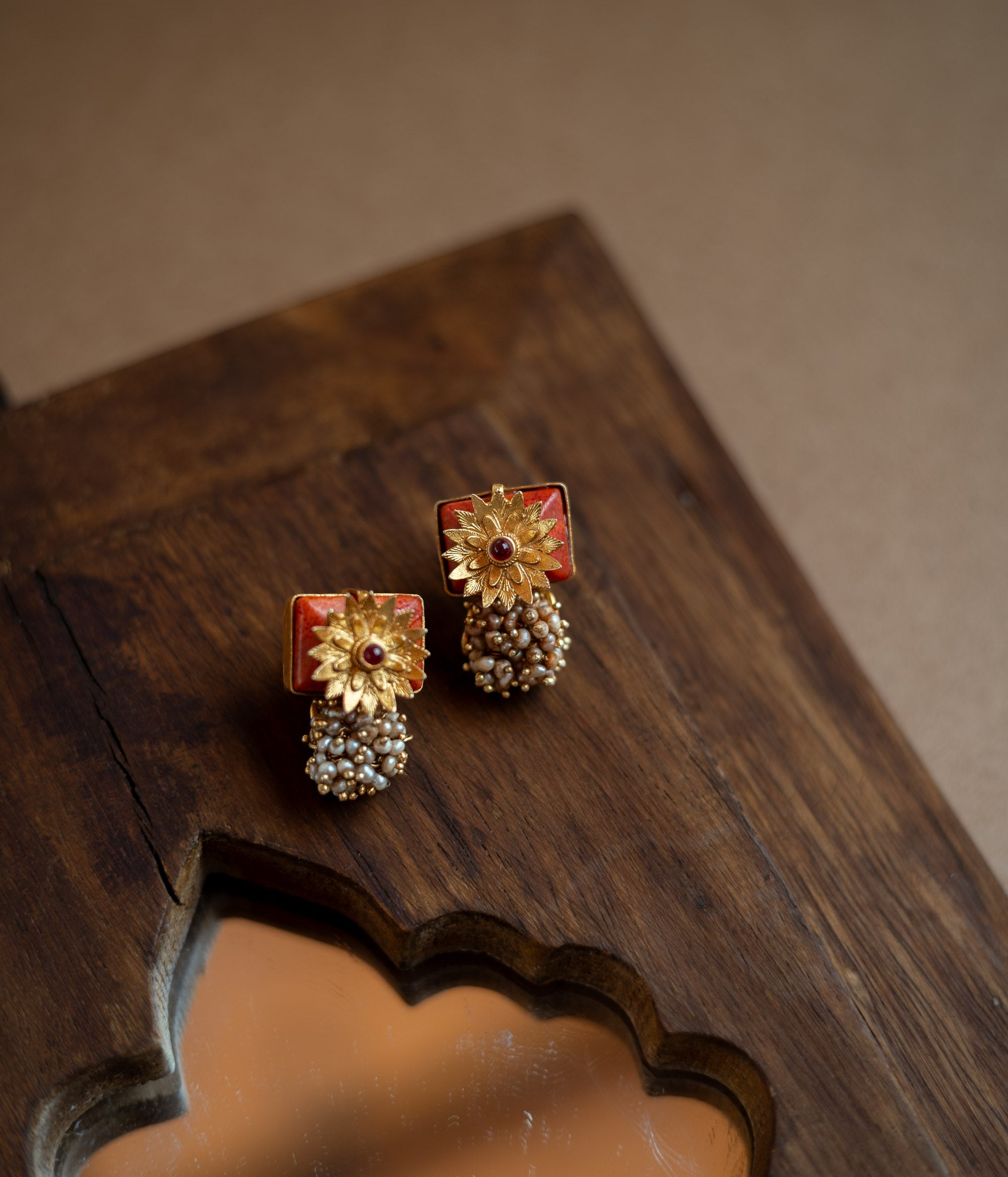 Bell-shaped earrings with a red spinel stone and pearl droplets.