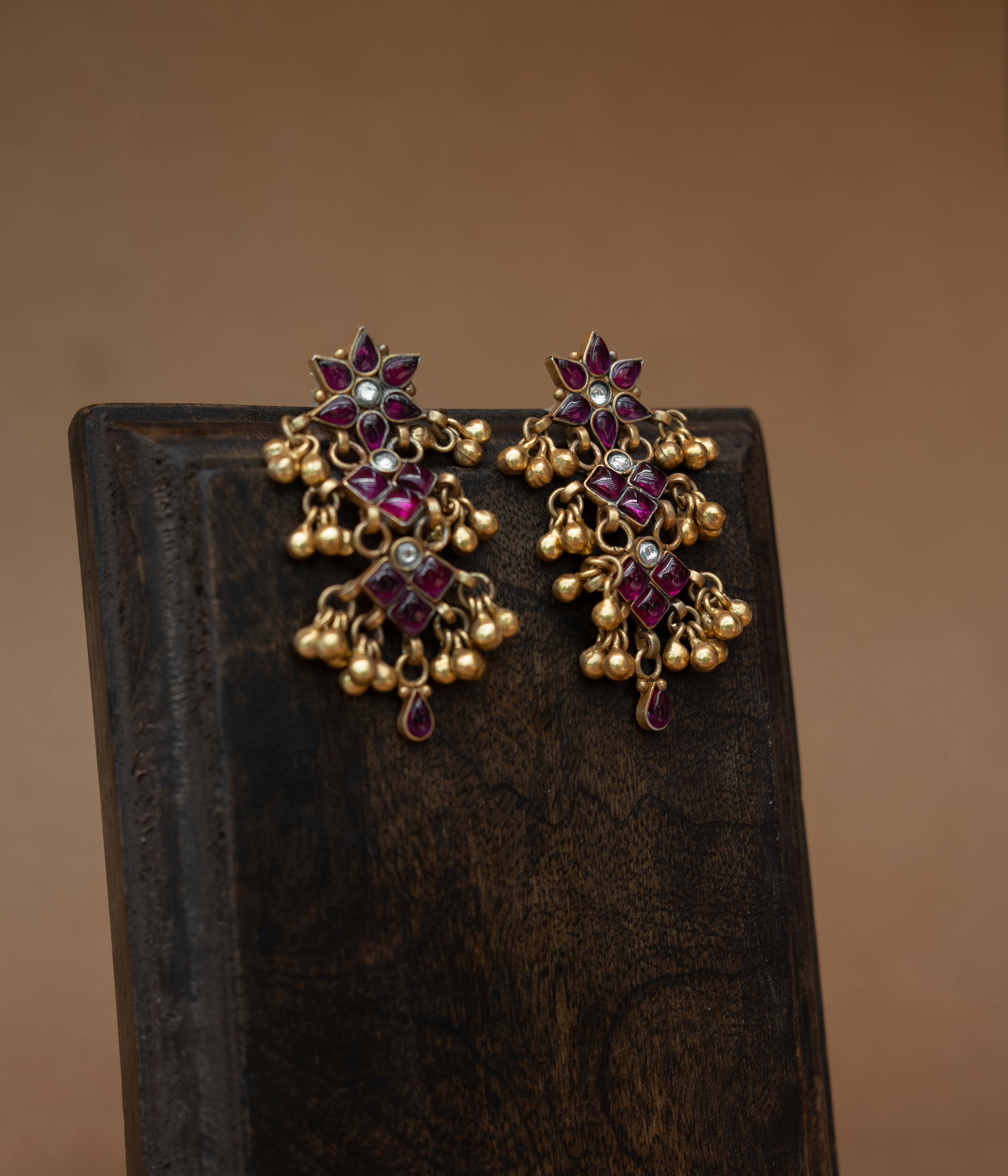 Tiered tribal earrings with red and white stones and small dangling drops.