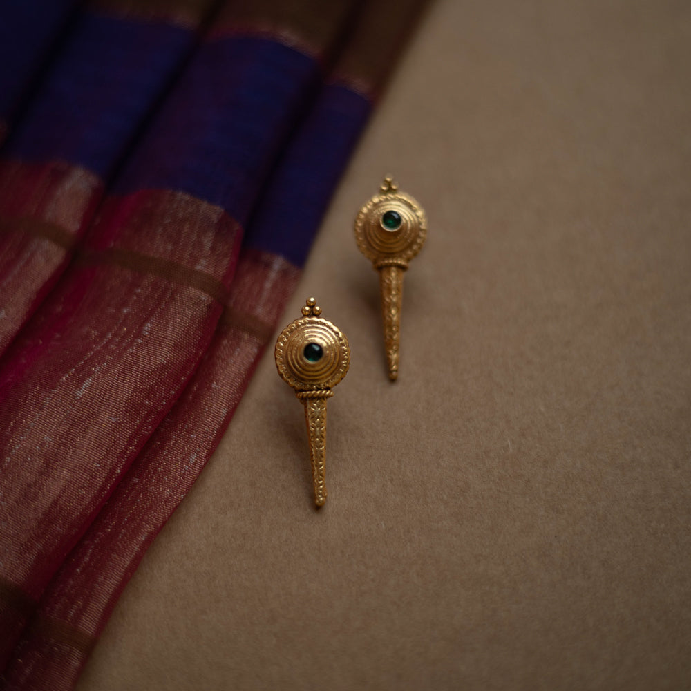 Antique gold stud earrings with a pointed, elongated design, each featuring a central green spinel stone.