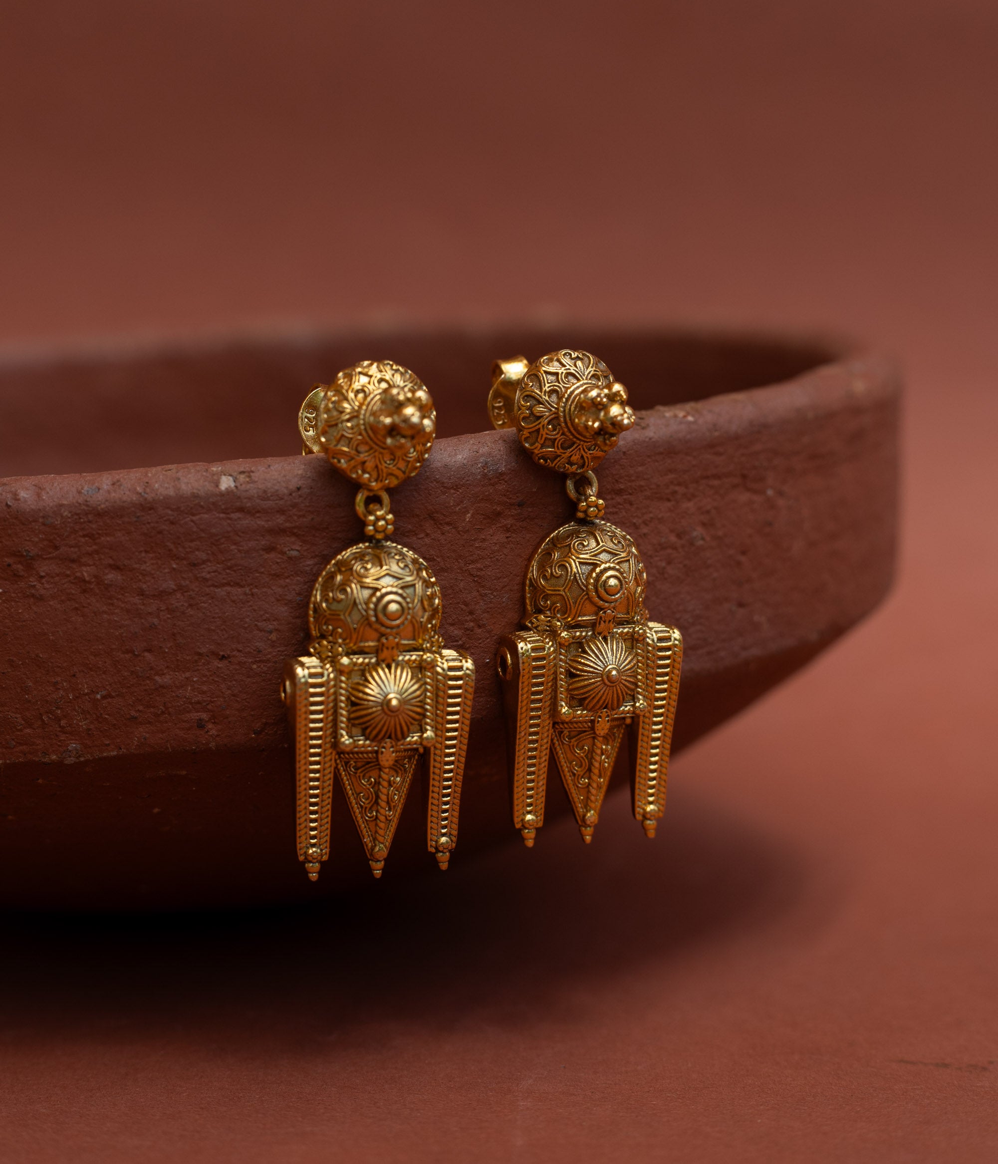 Sunburst motif silver tribal drop earrings close up