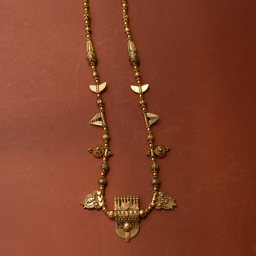 Traditional tribal gold necklace with temple motifs, half-moon shapes, and horn accents from Tribal Collection.
