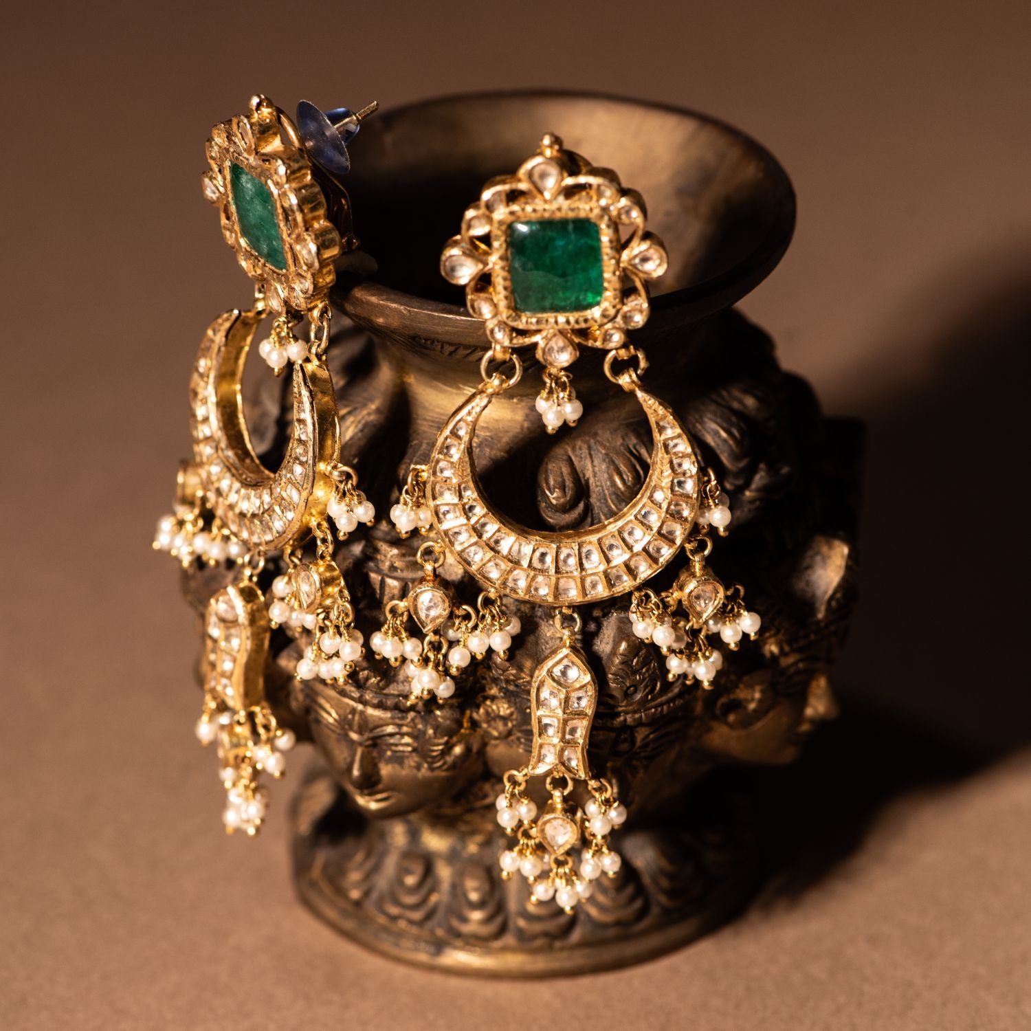 Gold-plated silver Chandbali earrings adorned with sparkling white sapphires, vibrant emeralds, and delicate freshwater pearls, creating an elegant and timeless traditional look.