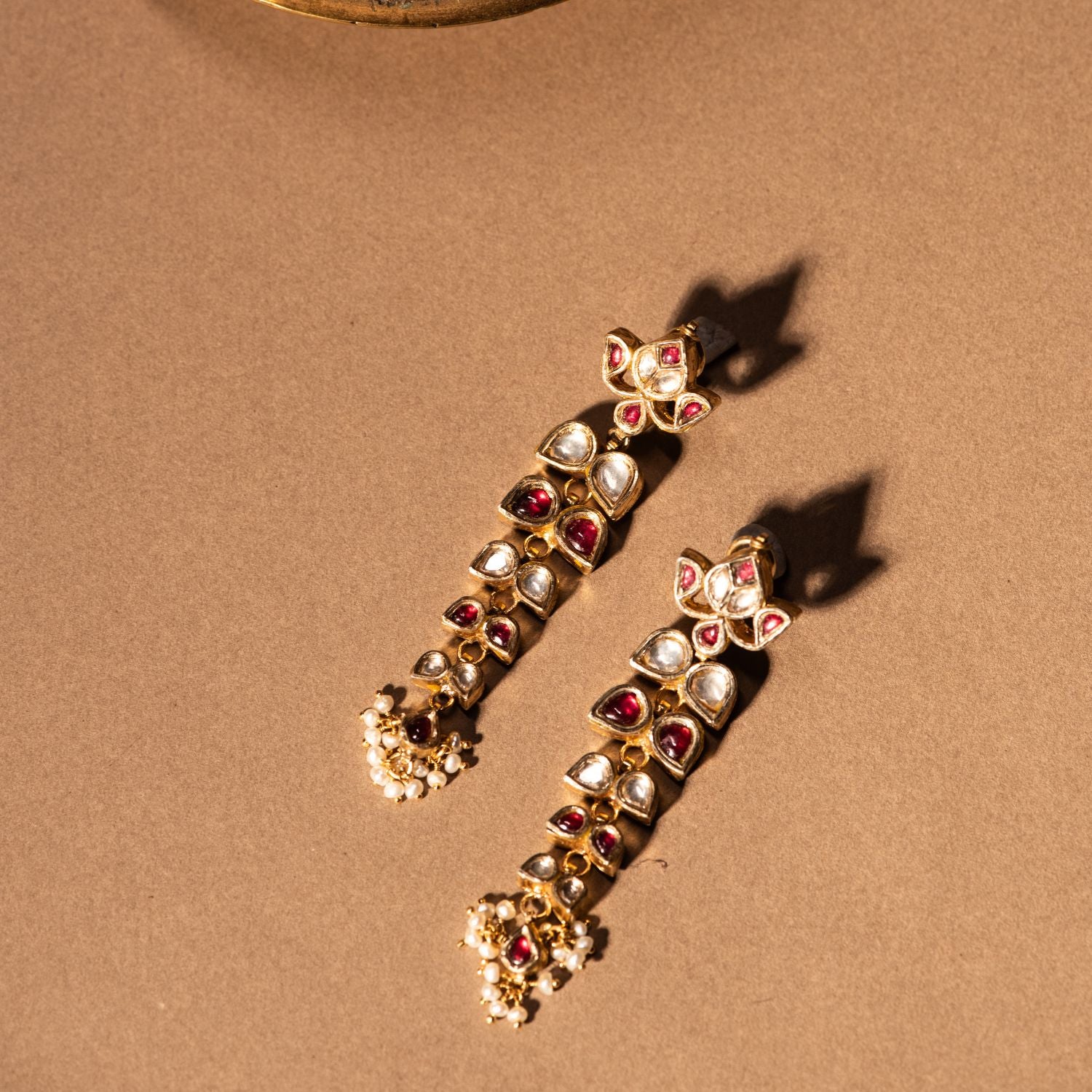 Gold-plated silver drop earrings adorned with sparkling white sapphires, vibrant red rubies, and elegant white pearls, creating a timeless and graceful design for any occasion.