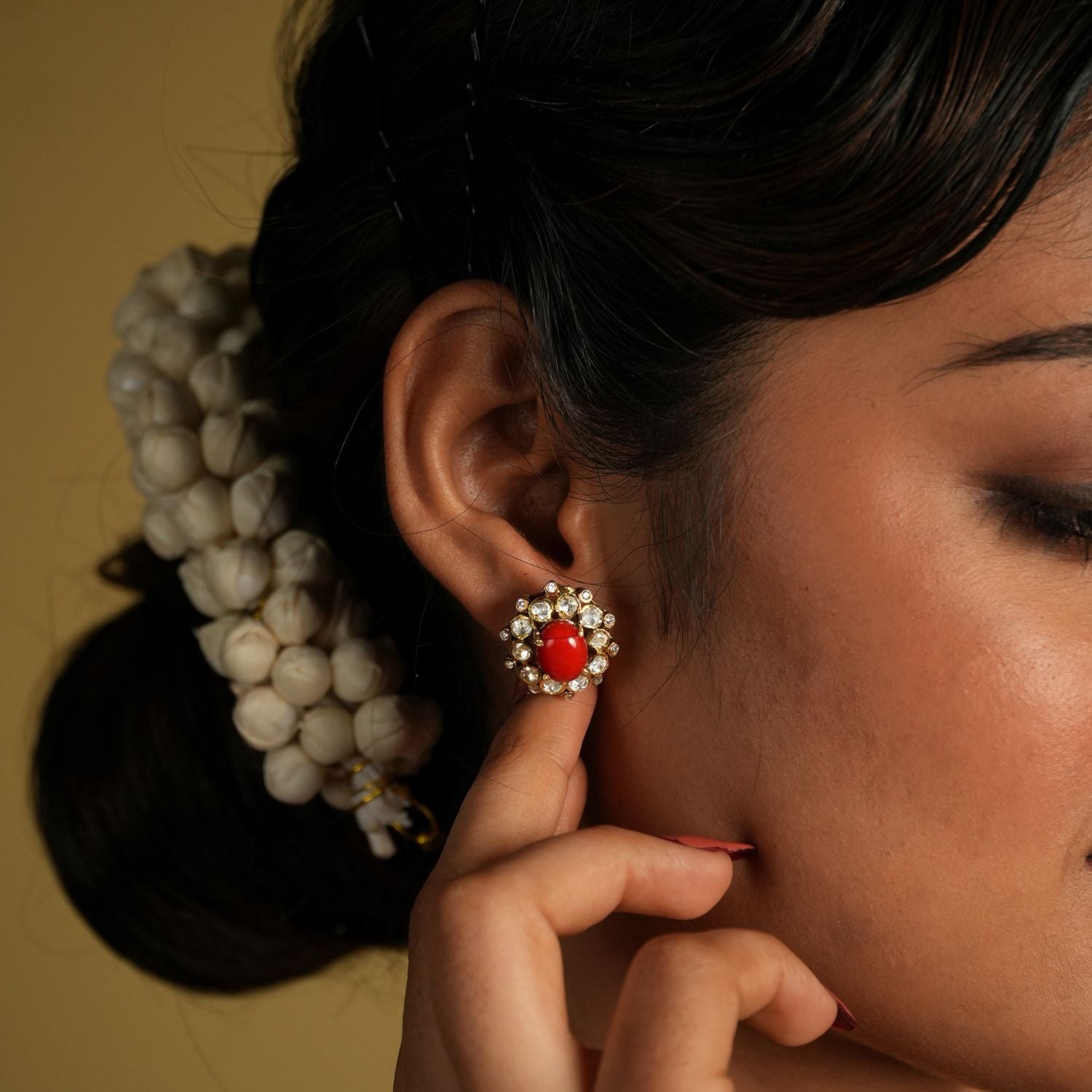 These delicate 92.5 sterling silver stud earrings showcase a vibrant coral gemstone at the center, surrounded by sparkling moissanite polkis that add a subtle yet elegant shine. The timeless design brings a perfect blend of tradition and sophistication.