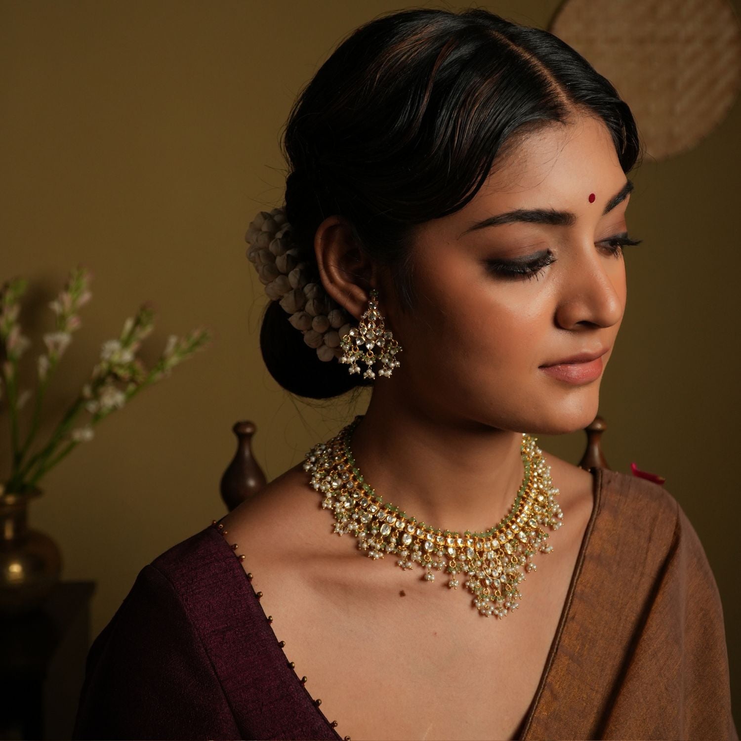 Elevate your traditional look with this exquisite silver gold-plated jewelry set, featuring a Kundan choker necklace and matching chandelier earrings.