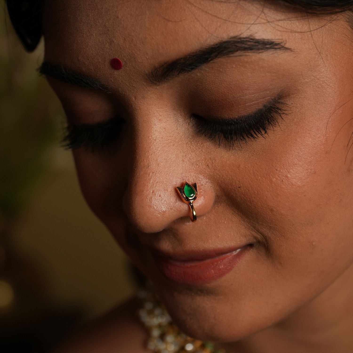 Enhance your beauty with this exquisite nose pin, featuring a mesmerizing spinel stone set in a delicate silver gold-plated frame. Designed for effortless elegance, this timeless piece showcases a pear-cut green spinel, symbolizing grace and sophistication.