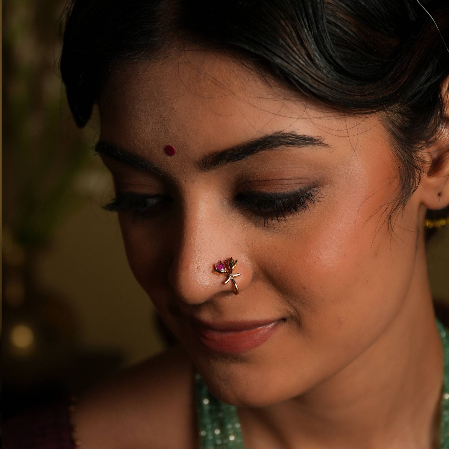 92.5 silver gold plated Petals of serenity, a delicate bloom... This minimal nose stud, featuring a double lotus bud
motif, shines with understated elegance. A subtle pink Kundan accent adds a touch of
natural beauty, evoking the peacefulness of a lotus flower. A tiny, timeless treasure that
exudes subtle sophistication.