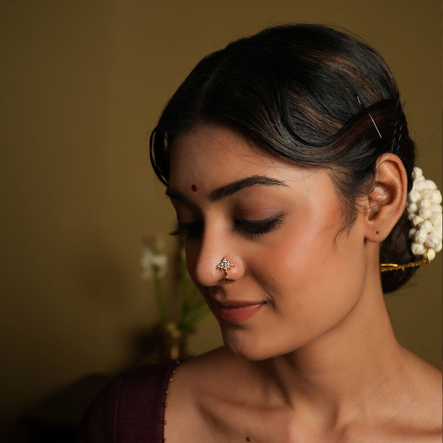 92.5 silver gold plated This minimal nose stud shines with modern elegance,
featuring moissanite set in geometric fashion. Inspired by vintage Chettinad stone setting, it
evokes the rich heritage of Indian craftsmanship. A tiny, timeless treasure that adds a touch
of subtle sophistication.