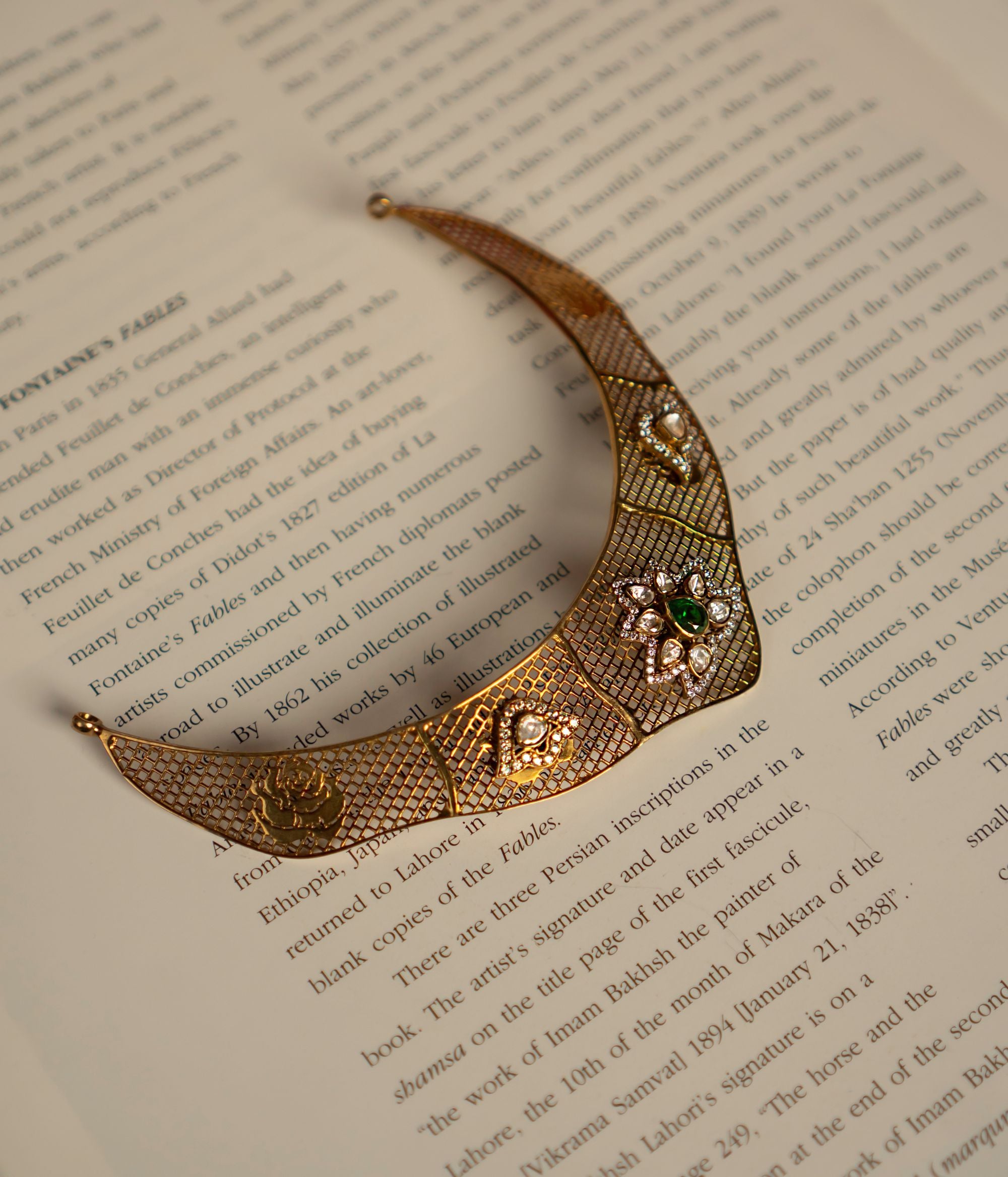 Elegant gold-plated silver choker featuring an intricate mesh design adorned with dazzling CZ stones, Polki stones, and vibrant green cut stones. The structured silhouette showcases a central Polki stone surrounded by fine detailing, complemented by green cut stones on either side, adding a regal touch. The fusion of textures and embellishments exudes a luxurious, vintage charm, making it a perfect statement piece.