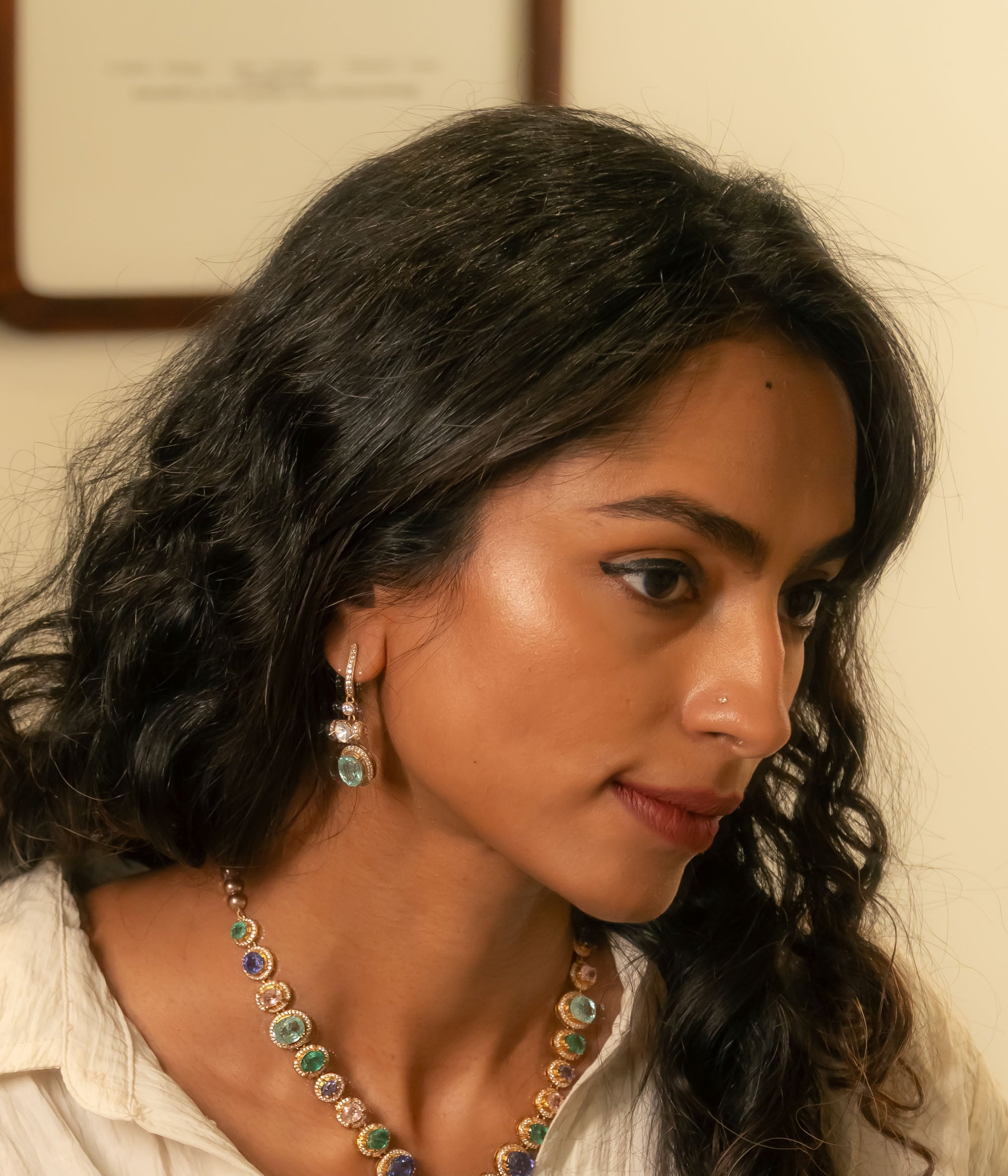 Gold Victorian hoop earrings with green gemstone, moissanite polki, and CZ stones, worn by a woman.