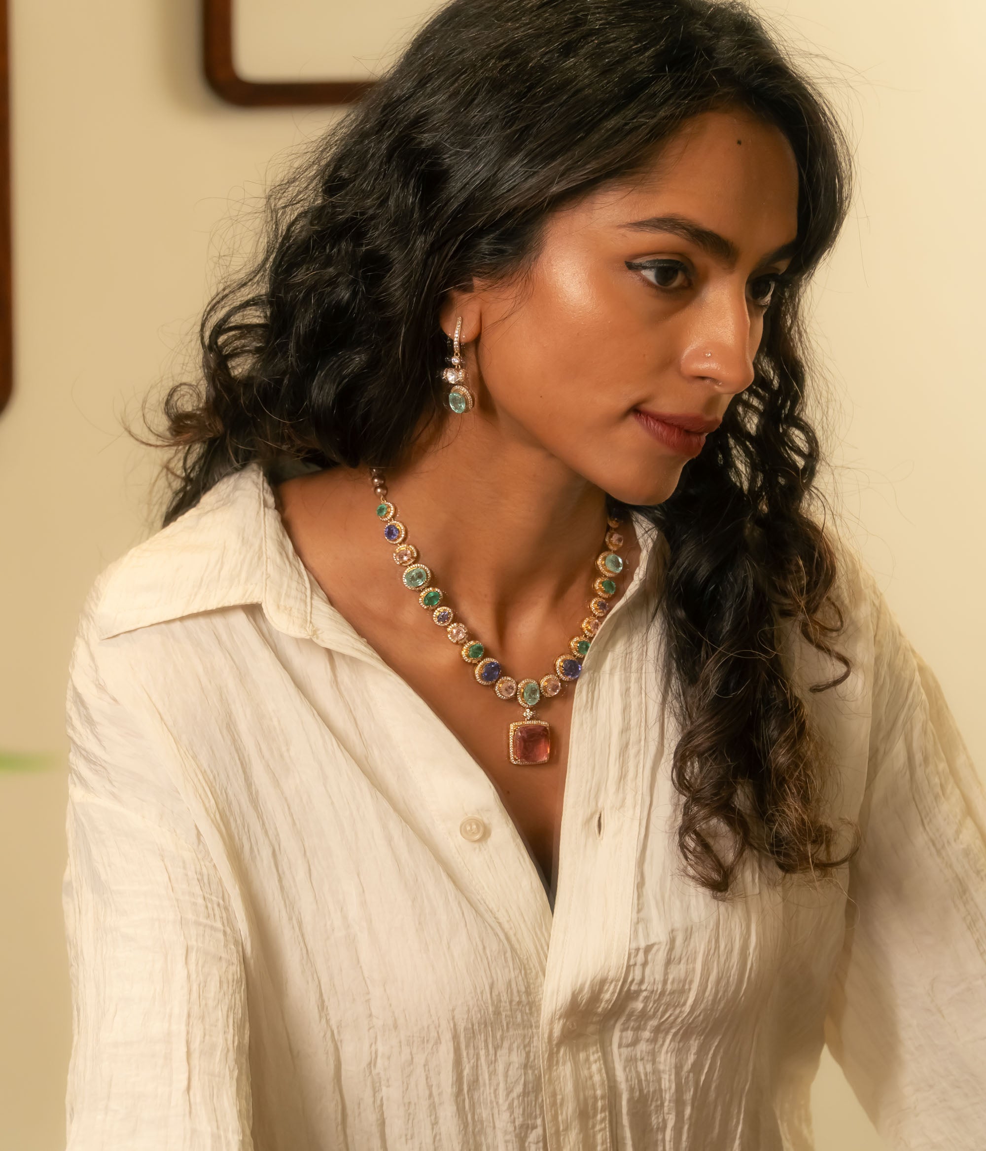 Gold Victorian hoop earrings with green gemstone, moissanite polki, and CZ stones, worn by a woman.